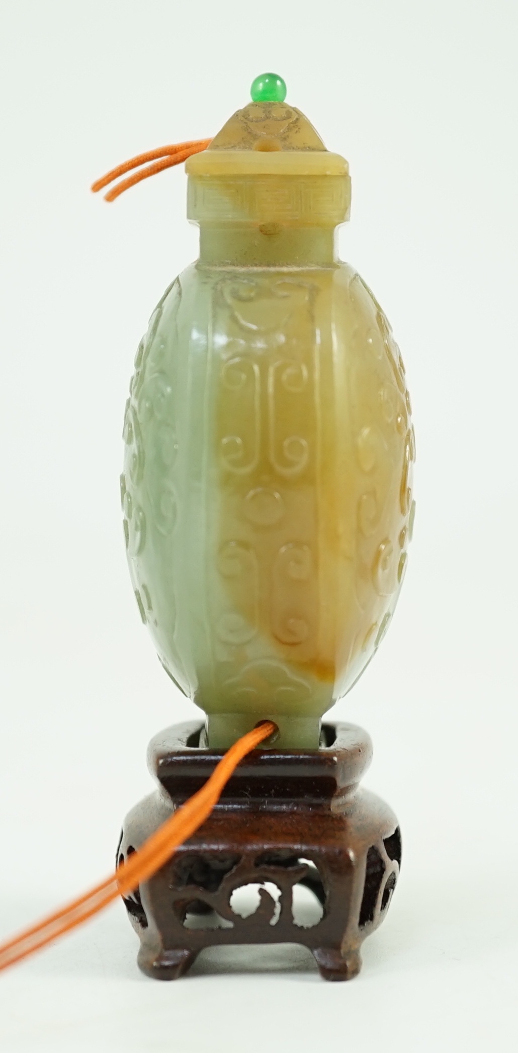 A Chinese archaistic green and russet jade miniature vase and cover, fanghu, 19th century, 6.7 cm high, foot re-carved, wood stand